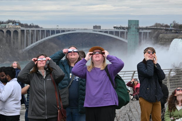 People look up at the sun during a total solar eclipse across North America, at Niagara Falls State Park in Niagara Falls, New York, on April 8, 2024. 