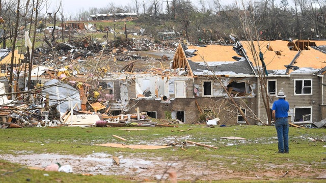 A man looks at debris on the ground after apartments were struck by a tornado in Selmer, Tennessee, April 3, 2025. 